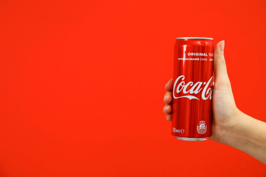 A hand holding a Coca-Cola can