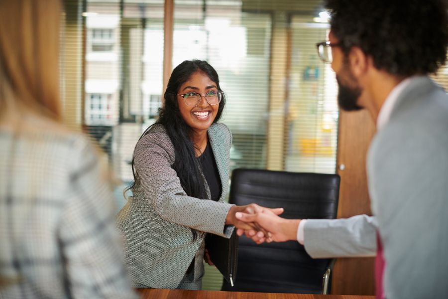 A woman shaking hands with a man after meeting for the first time