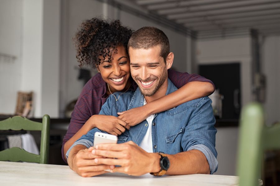 A man and woman looking at phone together