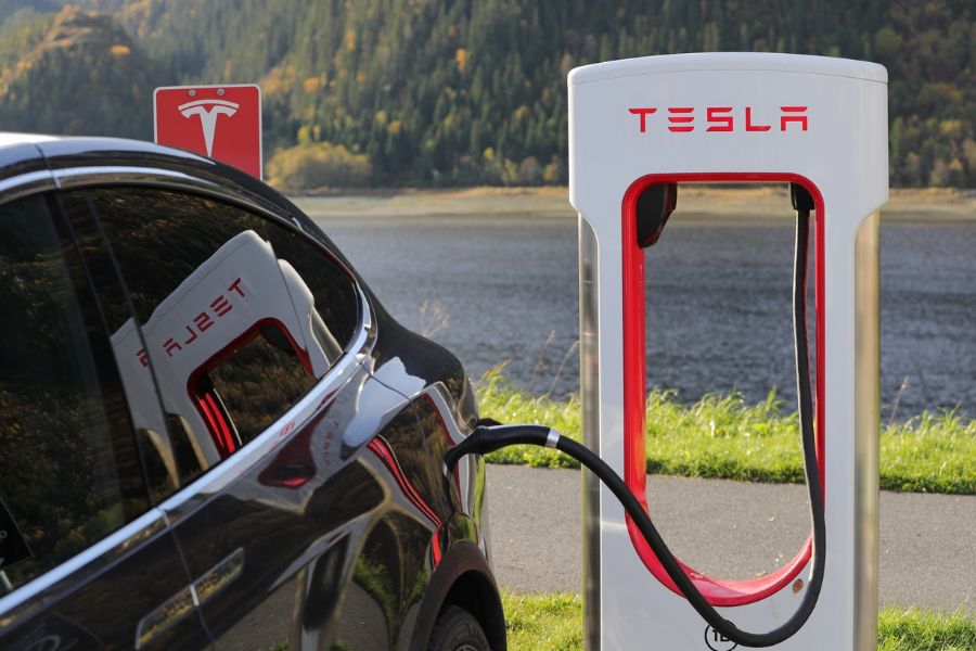 A Tesla car charging at a Tesla power station